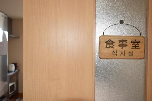 a wooden door with a sign on it at Minshuku Nishidomari in Tsushima