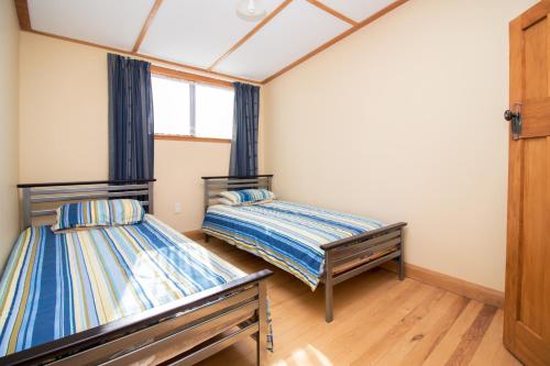 a room with two beds and a window at Langdale Lodge in Kurow