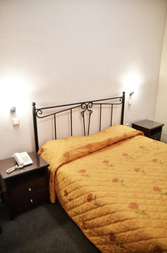 a bedroom with a bed and a table with a phone at Elatou in Áno Khóra