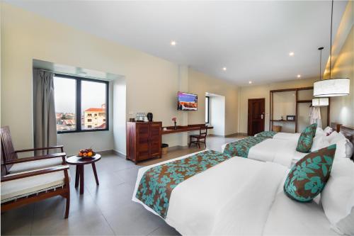 a hotel room with two beds and a desk at Bayon Modern Residence in Siem Reap