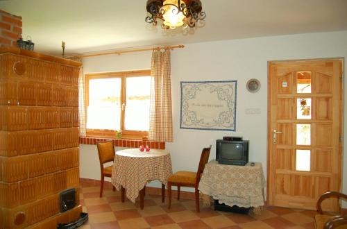 a dining room with a table and a tv at Nohab Apartman in Badacsonytördemic