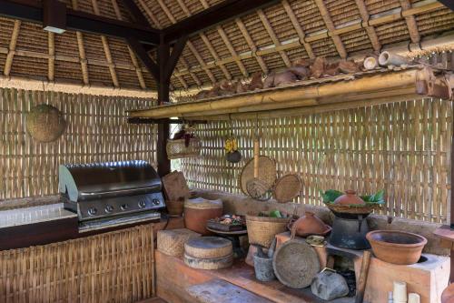 a kitchen with a stove and some pots and pans at Komaneka at Tanggayuda Ubud in Ubud