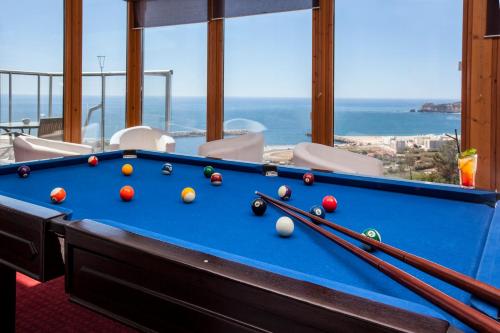 a pool table in a room with a view of the ocean at Hotel Miramar Sul in Nazaré