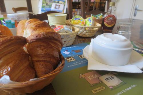 a table with a basket of bread and a croissant at Hotel Saint Etienne in Caen