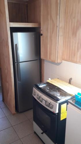 a kitchen with a stainless steel refrigerator and a stove at Cabaña Horcon in Puchuncaví