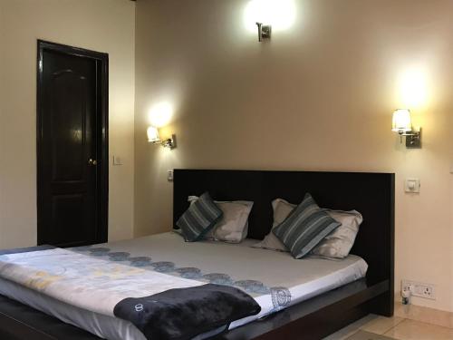 a large bed in a room with two lights at Karinya Villas in Nainital