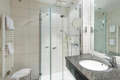 a bathroom with a sink and a glass shower at Hotel Domschenke in Billerbeck