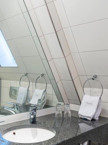a bathroom with a sink and a mirror at Hotel Domschenke in Billerbeck