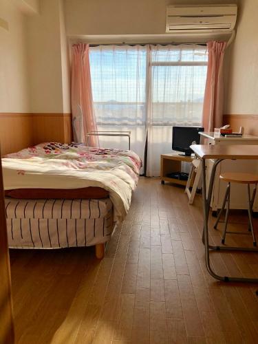 a bedroom with a bed and a desk and a window at Ichijyo Ivy in Kyoto