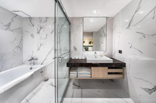 a white bathroom with a sink and a shower at K Hotel Taipei II in Taipei