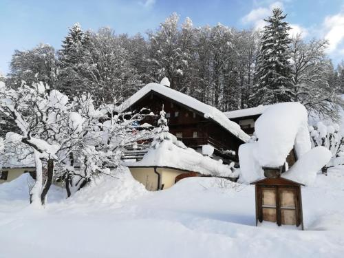 a log cabin covered in snow with a lantern at Gasthaus - Pension - Café Dörfl in Kiefersfelden