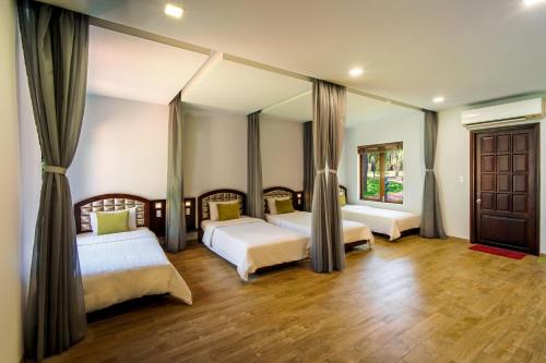 a bedroom with two beds and a mirror at Minera Hot Springs Binh Chau in Binh Chau