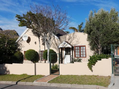 a white house with a fence and trees at Squirrels Corner in Montagu