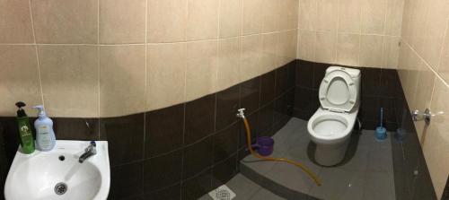 uma casa de banho com um lavatório e um WC em Wan Guest House em Pasir Mas