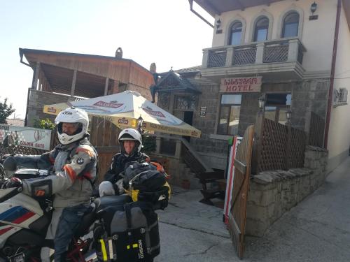 two men on a motorcycle parked in front of a building at Golden Gate in Akhaltsikhe