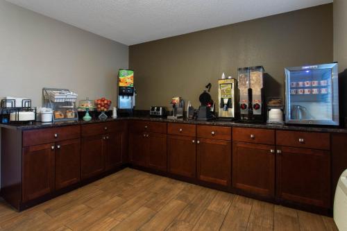 a kitchen with wooden cabinets and a counter top at Super 8 by Wyndham Cromwell/Middletown in Cromwell