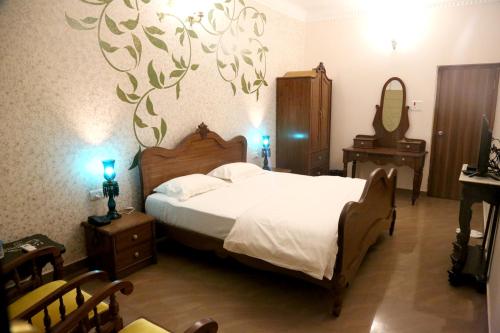 a bedroom with a large bed and a mirror at Vijaigarh Kothi - Heritage boutique in Varanasi