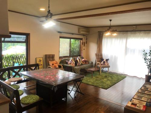 ein Wohnzimmer mit einem Sofa und einem Tisch in der Unterkunft Guesthouse Yui in Hongu