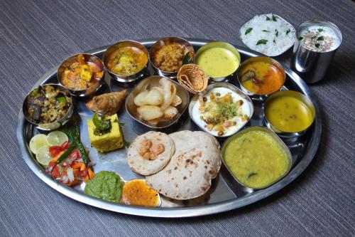 a tray of different types of food on a table at Hotel Grand Kadamba in Porvorim