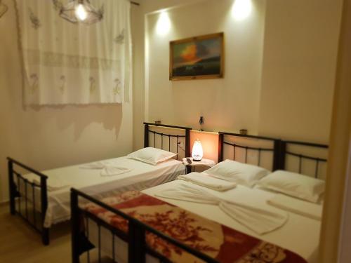 2 camas individuales en una habitación con ventana en Dimitri Guest House, en Përmet