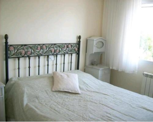 een bed met een kussen erop in een slaapkamer bij Haus mit Pool und Meerblick Altea in Altea