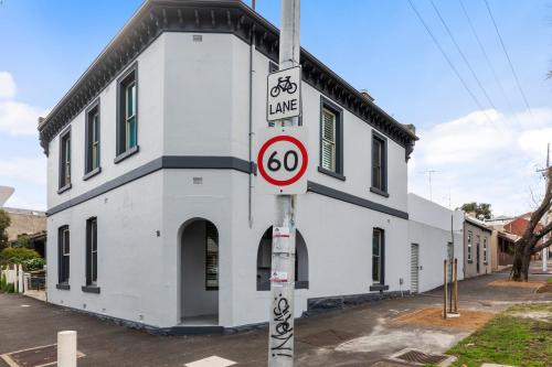 a white building with a bike lane sign in front of it at Work Sleep Live Melbourne in Melbourne