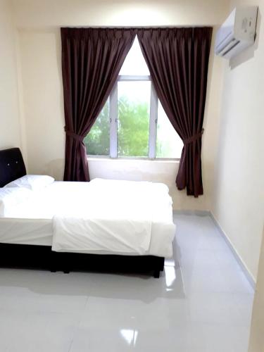 a bedroom with two beds and a window at Red Motel in Nibung Tebal