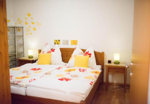 ein Schlafzimmer mit einem weißen Bett mit Blumen darauf in der Unterkunft Schmitzbergergut in Braunau am Inn