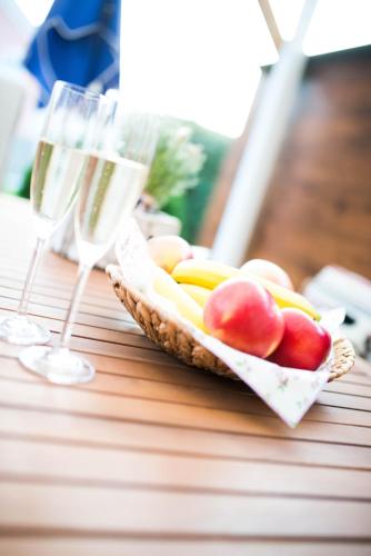 a basket of fruit and glasses of wine on a table at Schmitzbergergut in Braunau am Inn
