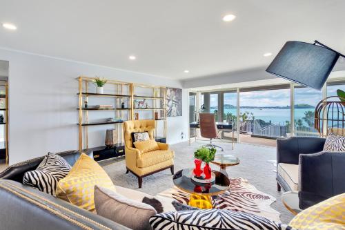 a living room with a couch and chairs at Orakei Grandeur Mansion with Sea Views & Pool in Auckland