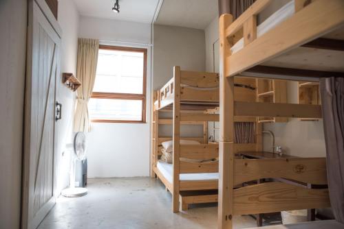 a room with two bunk beds and a window at 框框背包客棧 Kuang Kuang Hostel in Longjing