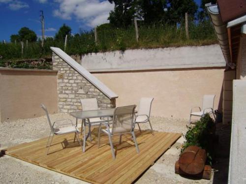une table et des chaises assises sur une terrasse en bois dans l'établissement Le Grenier, à Bief-des-Maisons