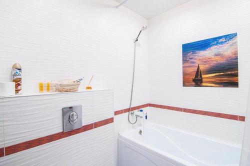 チュメニにあるAtma House однокомнатная квартира у Аквапаркаのバスルーム(壁に絵画が描かれたバスタブ付)