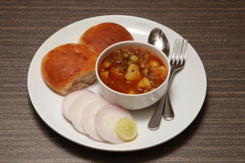 a plate of food with a bowl of soup and bread at Hotel Grand Kadamba in Porvorim