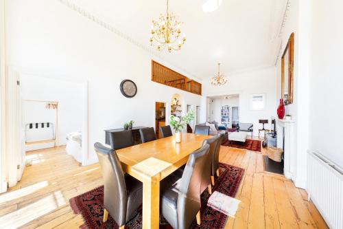 a dining room and living room with a wooden table and chairs at Elegant Period Clifton Balcony Apt - Simplycheckin in Bristol