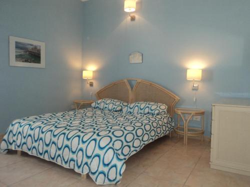 シラクーサにあるB&B Mare Di S. Luciaのベッドルーム1室(ベッド1台、テーブル2台、ランプ2つ付)