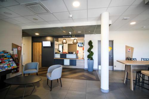 a lobby of a store with chairs and a table at B&B HOTEL Montélimar Sud in Montélimar