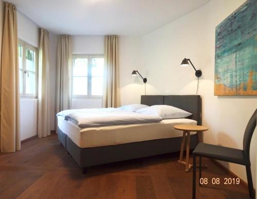 a bedroom with a bed and two lamps and a chair at Huge and Calm Apartment in Central Garmisch in Garmisch-Partenkirchen