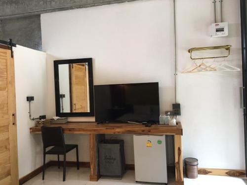 a room with a desk with a television and a mirror at Home Ayutthaya in Phra Nakhon Si Ayutthaya