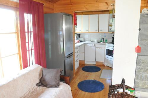 uma cozinha com um sofá e um frigorífico em Suvaksen Helmi em Kosula