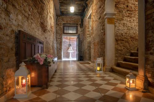 a hallway with a checkered floor and a woman in a white dress walking at Dimora Al Doge Beato vista canale in Venice