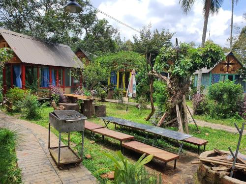 a group of benches and a grill in a yard at Garden Homestay in Di Linh