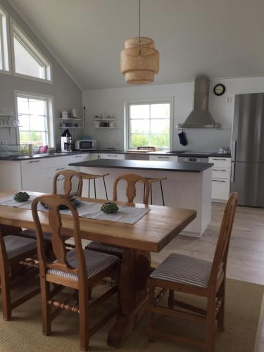 a kitchen with a wooden table and four chairs at Kungsbacken i Tived in Tived