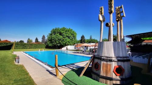 a swimming pool with a statue next to it at Almtalhotel Appartements in Pettenbach in Pettenbach