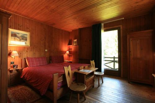 シャンポルクにあるAlbergo Villa Anna Mariaのベッドルーム1室(ベッド1台、テーブル、椅子付)
