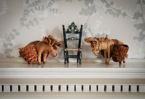 three statues of elephants and a chair on a mantel at Kelly House Country B&B in Lifton