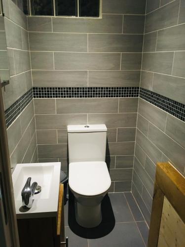 a bathroom with a white toilet and a sink at La Rénovée d’Antan in Avallon