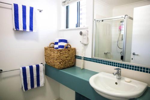 La salle de bains est pourvue d'un lavabo et d'un miroir. dans l'établissement Tropical Getaway in 2 Bedroom Unit in 4 star Resort, à Noosaville
