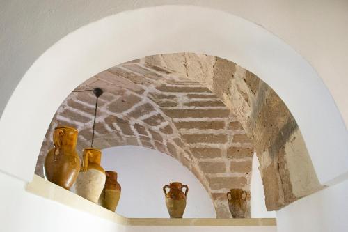 an archway with vases on a shelf in a room at Tenuta Afra in Squinzano
