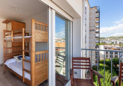 a bedroom with bunk beds and a balcony with a view at Hola! - El Cortijo in Sitges